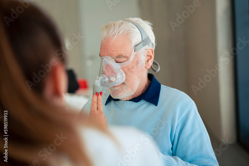 Doctor helping patient using nebulizer photo