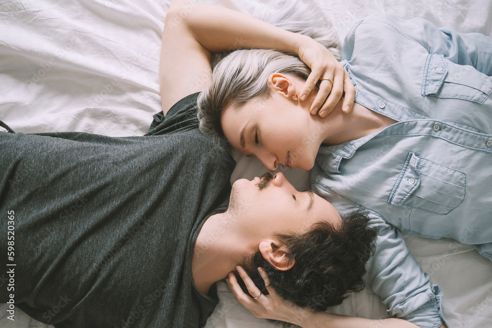 Man and woman lying on bed and embracing each other Man and woman lying on bed and embracing each other