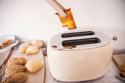 Cooking tongs removing bread toast from toaster photo