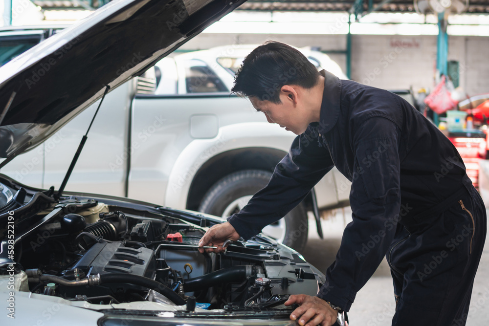 Portrait of a mechanic repairing a car in garage, Auto mechanic working in garage, Maintenance and Repair service. Portrait of a mechanic repairing a car in garage, Auto mechanic working in garage, Maintenance and Repair service.
