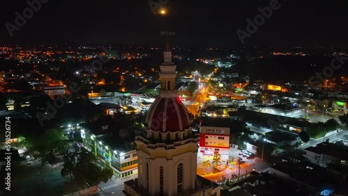 Sacred Heart of Jesus Church or Iglesia Sagrado Corazón De Jesus at night with moon in dark sky, Moca in Dominican Republic