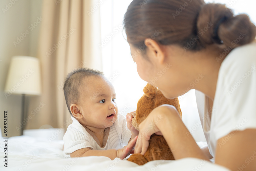 Close up portrait of beautiful young asian mother and her newborn baby in a bed.authentic of asian mom feeds her baby from bottle and she feels happiness.Concept of mom day,parenthood,asian family. Close up portrait of beautiful young asian mother and her newborn baby in a bed.authentic of asian mom feeds her baby from bottle and she feels happiness.Concept of mom day,parenthood,asian family.