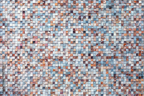 Abstract patterned wall made of small square stones photo