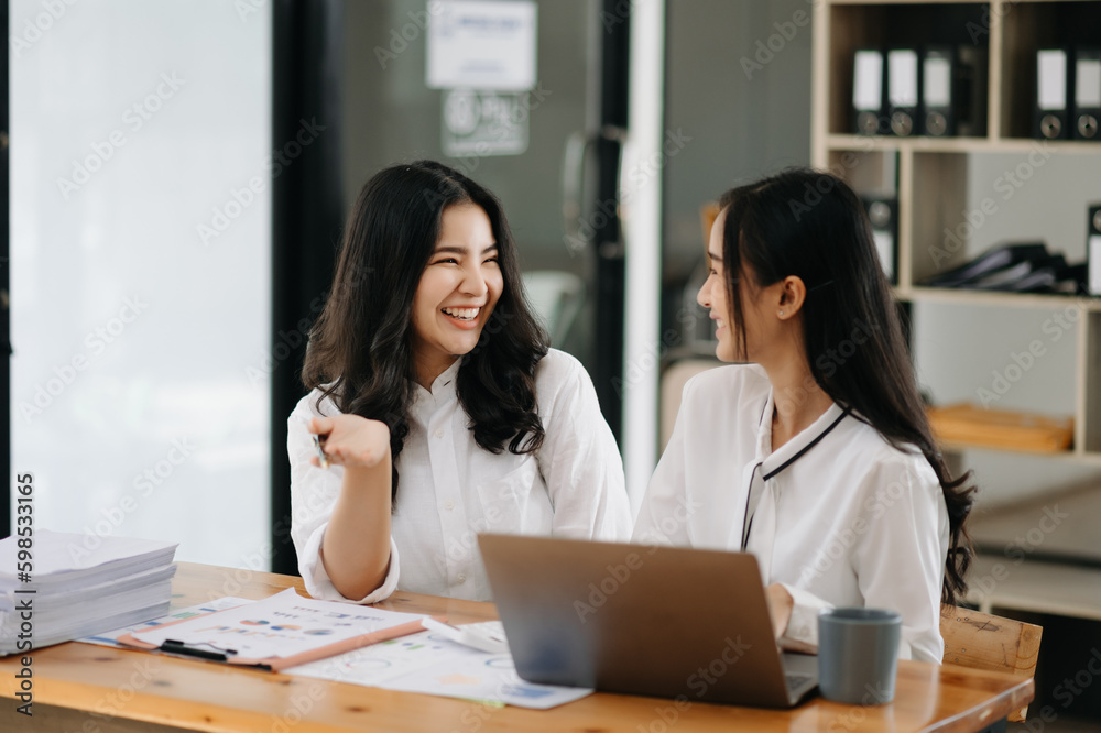 Two Asian businesswoman discuss investment project working and planning strategy with tablet laptop computer in office. Two Asian businesswoman discuss investment project working and planning strategy with tablet laptop computer in office.