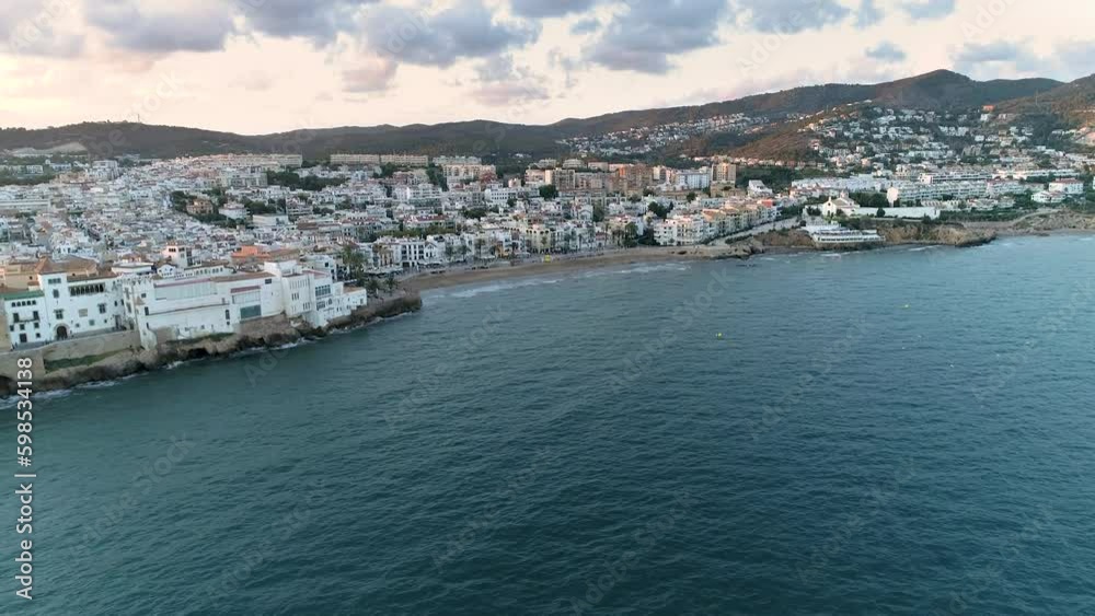 Aerial view of Sitges coastline at sunset. Sant Bartomeu i Santa Tecla church. Famous beaches near Barcelona. Aerial view of Sitges coastline at sunset. Sant Bartomeu i Santa Tecla church. Famous beaches near Barcelona.