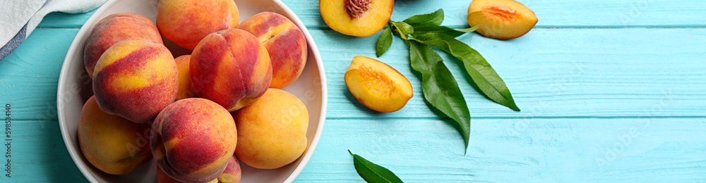 Fresh ripe peaches and green leaves on light blue wooden table, flat lay. Banner design with space for text Fresh ripe peaches and green leaves on light blue wooden table, flat lay. Banner design with space for text