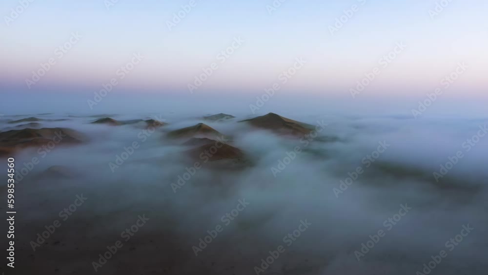 Aerial view overlooking fog covered sand dunes, dawn in the Namib desert of Namibia Aerial view overlooking fog covered sand dunes, dawn in the Namib desert of Namibia