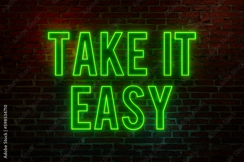 Take it easy, neon sign. Brick wall at night with the text Take it easy, neon sign. Brick wall at night with the text