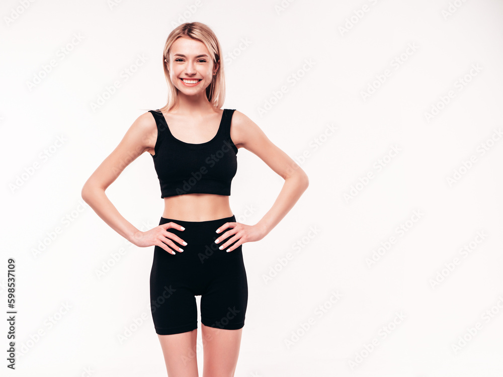 Young beautiful smiling blond female in black cycling shorts clothes. Sexy carefree woman posing on white background in studio. Positive model having fun indoors. Cheerful and happy Young beautiful smiling blond female in black cycling shorts clothes. Sexy carefree woman posing on white background in studio. Positive model having fun indoors. Cheerful and happy