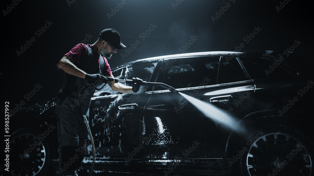 Brand New Electric Vehicle from a Production Line is Being Rinsed From Foam with a Pressure Washer. Factory Fresh SUV in a Detailing Car Wash Before Getting Waxed and Ceramic Coated for Protection