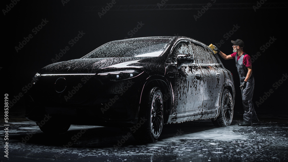 Foto de Professional Car Wash Specialist Spreading Foam with a Soft