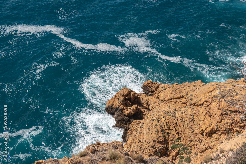 Beautiful aerial view on blue turquoise Mediterranean sea and rocks from above near Albir lighthouse, Serra Gelada national park, Alicante province, Spain