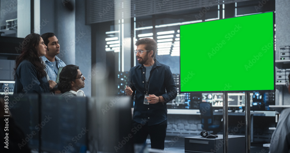Team of Diverse South Asian Information Technology Experts Having a Meeting in a Conference Room with Green Screen Mock Up Display. Team Leader Making a Presentation for Project Managers at the Office Team of Diverse South Asian Information Technology Experts Having a Meeting in a Conference Room with Green Screen Mock Up Display. Team Leader Making a Presentation for Project Managers at the Office