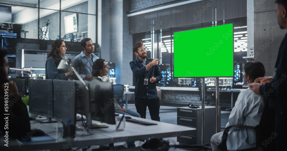 Group of Multiethnic Software Developers Having a Meeting in a Conference Room with Green Screen Mock Up Display. Indian Specialists Brainstorming New Ideas and Solving Problems in the Office