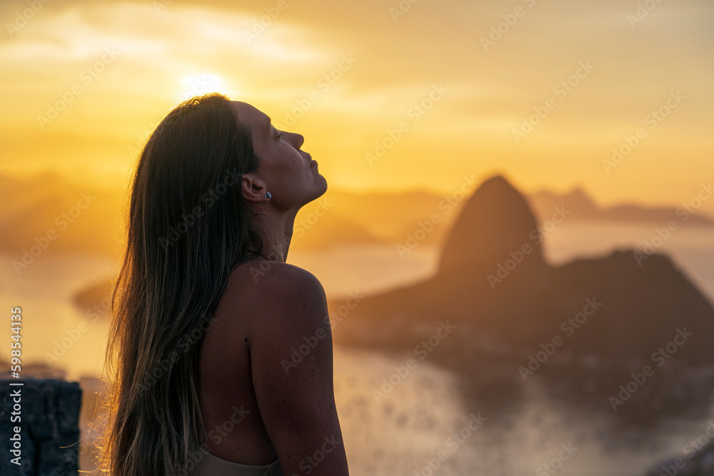 tourist contemplating sunrise at the Dona Marta lookout with the Sugarloaf Mountain in the background tourist contemplating sunrise at the Dona Marta lookout with the Sugarloaf Mountain in the background