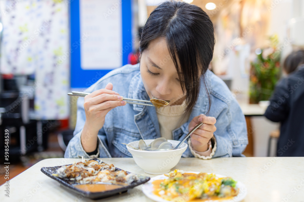 Travel woman enjoy Taiwanese cuisine with clam and oyster at restaurant Travel woman enjoy Taiwanese cuisine with clam and oyster at restaurant