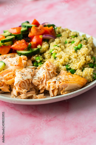 Healthy lunches, quinoa with green peas, with baked red fish salmon and fresh salad of tomato, cucumber and greens