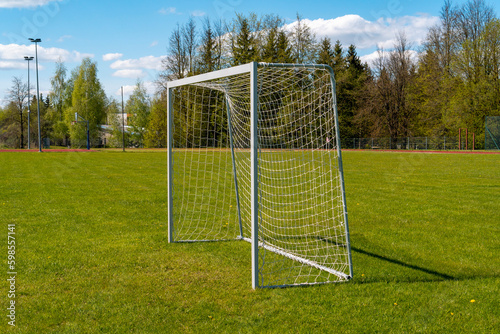 Sports field with mini goal and net on meadow