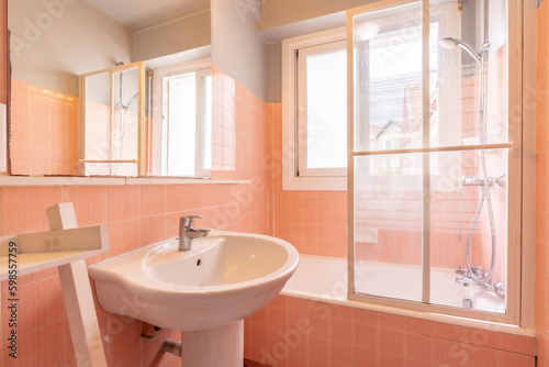 Home bathroom  bright new bathroom interior with tiled glass shower  vanity cabinet  interior designed white and pink