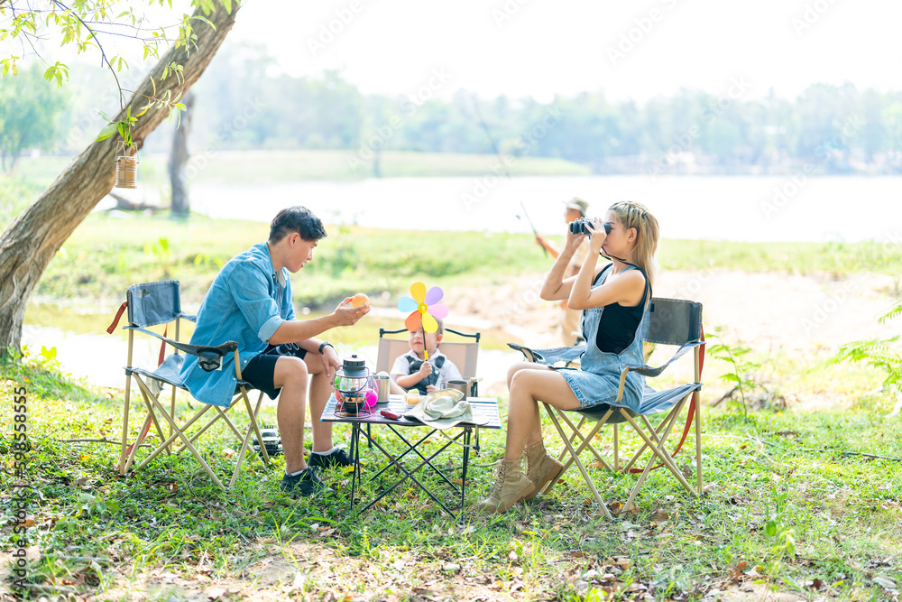 Fototapeta premium Family enjoying a camping holiday in the countryside ,Camping, travel, tourism, hiking and people. Concept - Happy family with backpacks and thermos at camp.