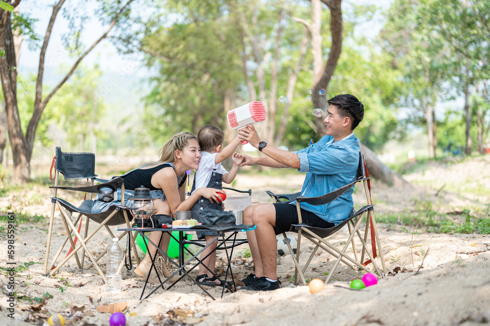 Family enjoying a camping holiday in the countryside ,Camping, travel, tourism, hiking and people. Concept - Happy family with backpacks and thermos at camp.