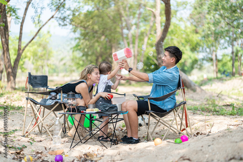 Family enjoying a camping holiday in the countryside ,Camping, travel, tourism, hiking and people. Concept - Happy family with backpacks and thermos at camp.