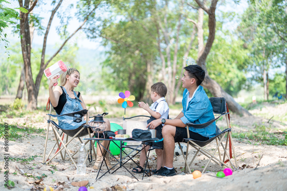 Family enjoying a camping holiday in the countryside ,Camping, travel, tourism, hiking and people. Concept - Happy family with backpacks and thermos at camp. Family enjoying a camping holiday in the countryside ,Camping, travel, tourism, hiking and people. Concept - Happy family with backpacks and thermos at camp.