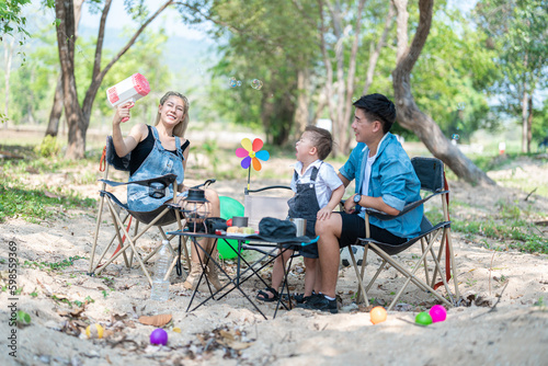 Family enjoying a camping holiday in the countryside ,Camping, travel, tourism, hiking and people. Concept - Happy family with backpacks and thermos at camp.