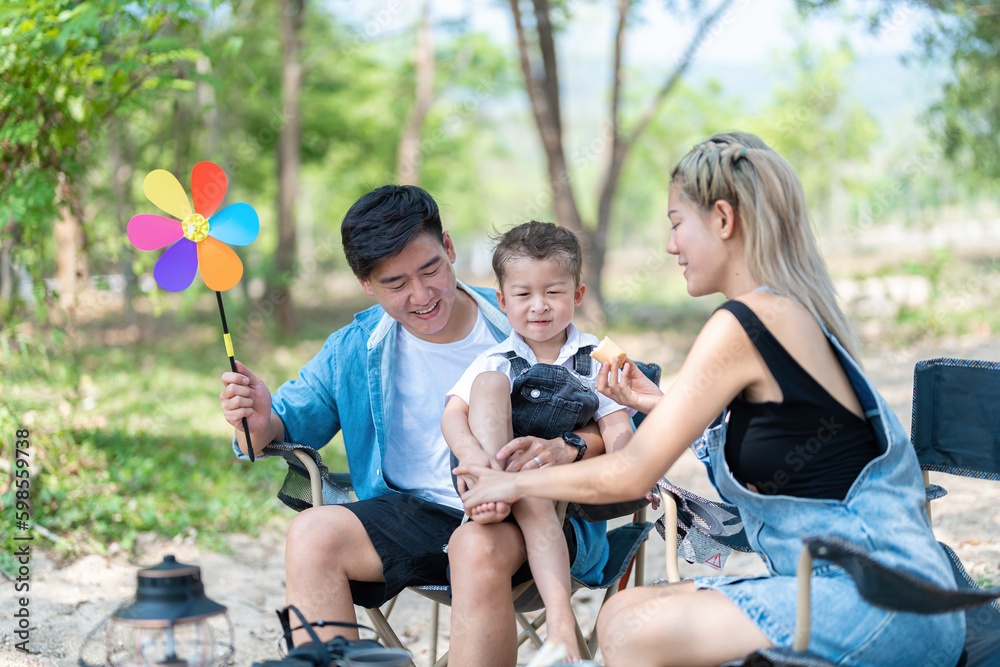 Family enjoying a camping holiday in the countryside ,Camping, travel, tourism, hiking and people. Concept - Happy family with backpacks and thermos at camp. Family enjoying a camping holiday in the countryside ,Camping, travel, tourism, hiking and people. Concept - Happy family with backpacks and thermos at camp.