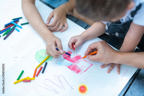 A family draws on paper lying on their free time on the table.