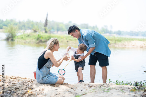Family activity to scoop fish in a natural stream in the countryside.