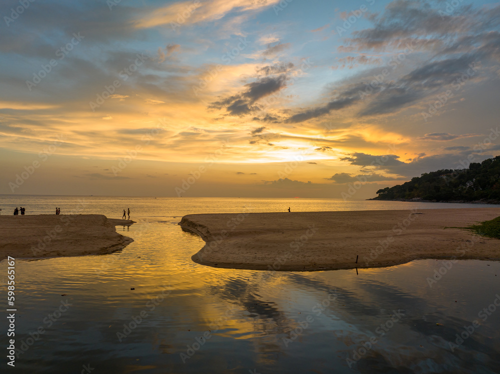 aerial view stunning reflection of bright golden sky in a canal at Karon beach Phuket.
Imagine a fantasy colorful clouds changing in sky of sunset.
Gradient color. Sky texture,  nature background.