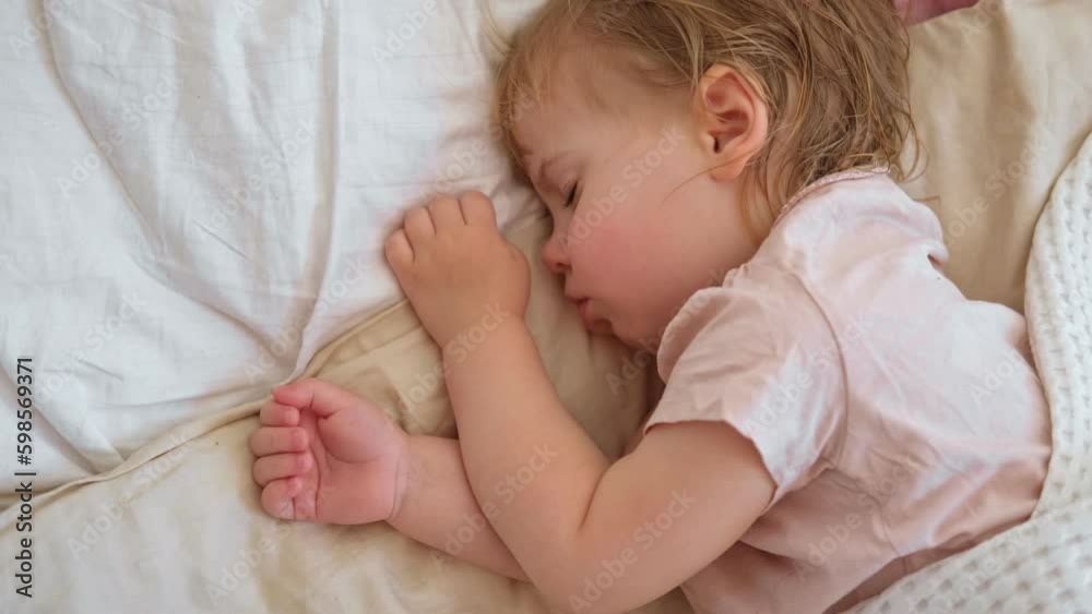 Peaceful adorable baby sleeping on his bed at home. Sleeping newborn baby concept. One year old baby girl sleeps peaceful at domestic room interior background. Serene dream. Cute Face Close Up. Peaceful adorable baby sleeping on his bed at home. Sleeping newborn baby concept. One year old baby girl sleeps peaceful at domestic room interior background. Serene dream. Cute Face Close Up.