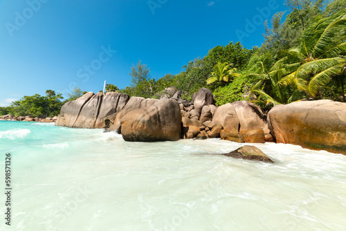 Granite rocks and palm trees by the sea in world famous Anse Lazio beach