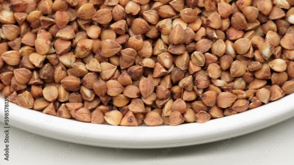 Buckwheat Groats Dry Uncooked Raw Natural Fresh Brown Rotating. Roasted buckwheat kernels. Healthy organic food. Background. Buckwheat Groats Dry Uncooked Raw Natural Fresh Brown Rotating. Roasted buckwheat kernels. Healthy organic food. Background.