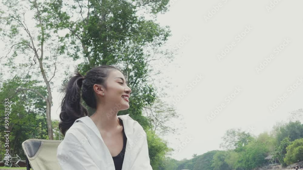 Young Asian female is enjoy traveling and spend time among nature river. Chilling and relief. Concept of calm cozy day dreaming recreation, satisfaction, inspiration and vacation with copy space Young Asian female is enjoy traveling and spend time among nature river. Chilling and relief. Concept of calm cozy day dreaming recreation, satisfaction, inspiration and vacation with copy space
