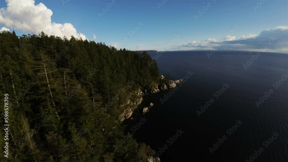Flying around the rocky coast of the Pacific Ocean in Howe Sound. Vancouver, BC, Canada. Aerial. Sunset