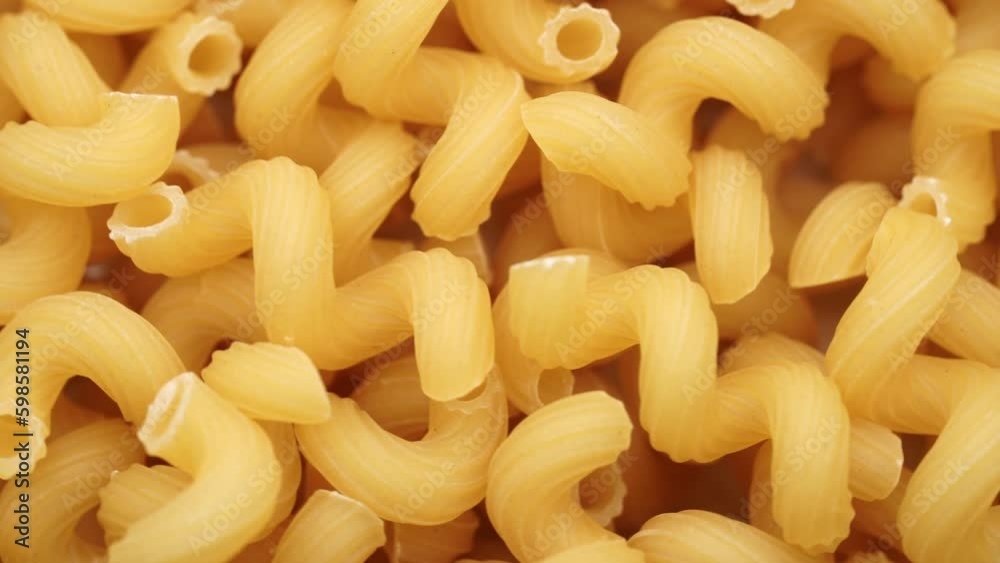 Background of Uncooked Noodles that Slowly Rotating. Texture of Dry Vermicelli Turning Around. Raw Pasta. Bunch of raw pasta spins in a circle Background of Uncooked Noodles that Slowly Rotating. Texture of Dry Vermicelli Turning Around. Raw Pasta. Bunch of raw pasta spins in a circle