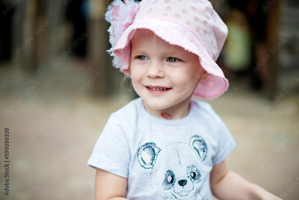 Smiling cute preschool girl in pink hat outdoors. Close portrait.Concept of happy childhood, outdoor games. Smiling cute preschool girl in pink hat outdoors. Close portrait.Concept of happy childhood, outdoor games.