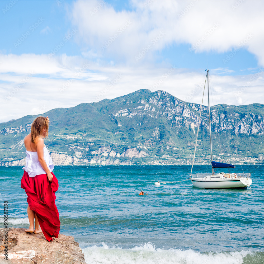 Woman in red dress staying at the lake