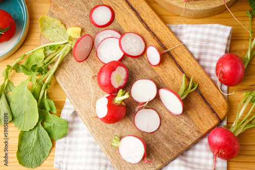 Fresh red radish slices on a wooden background, top view.