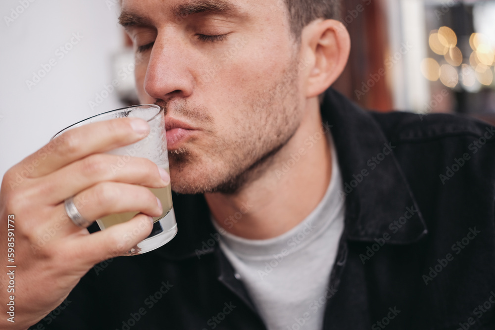 A man kissing a glass with a drink A man kissing a glass with a drink