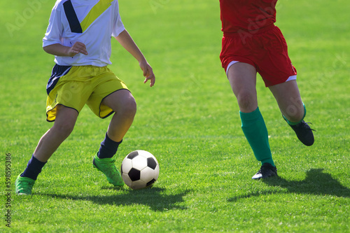 Fototapeta Naklejka Na Ścianę i Meble -  Soccer Players in a Duel on Grass  Running After Soccer ball