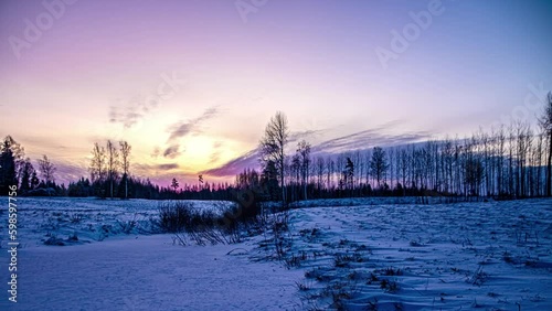 Night to day timelapse of firey red sunrise blanket cloud cover over snowy meadow photo