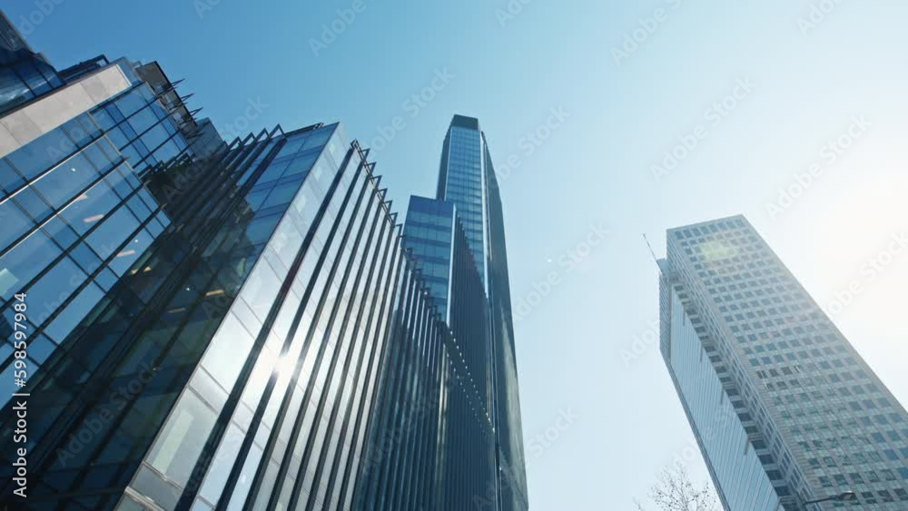 High rise skyscrapers cityscape low angle dolly shot, financial district looking up modern architecture office buildings, city downtown business center gimbal wide shot from below, clear blue sky High rise skyscrapers cityscape low angle dolly shot, financial district looking up modern architecture office buildings, city downtown business center gimbal wide shot from below, clear blue sky