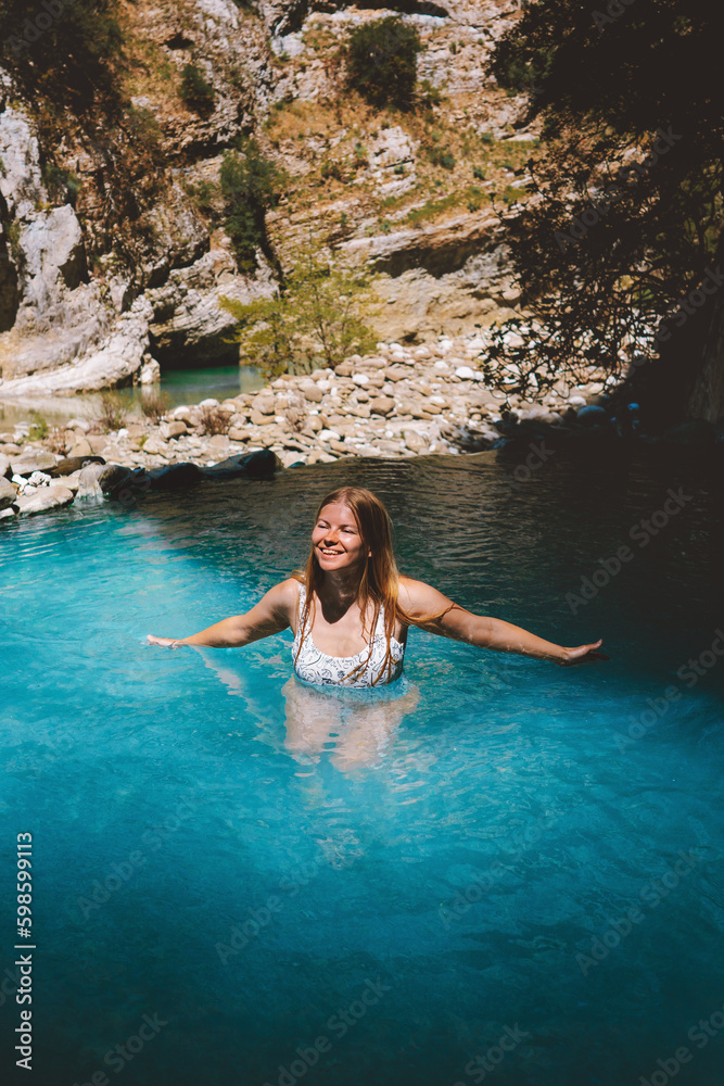Woman swimming in a hot spring outdoor happy smiling girl traveling in Albania relaxing in natural pool Benja thermal bath summer vacations healthy lifestyle