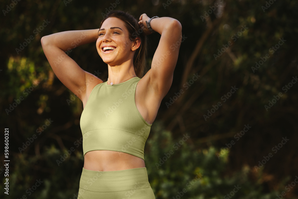 Woman warming up for a morning workout outdoors - obrazy, fototapety, plakaty 