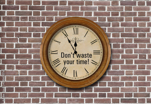 round clock in a frame on a brick wall