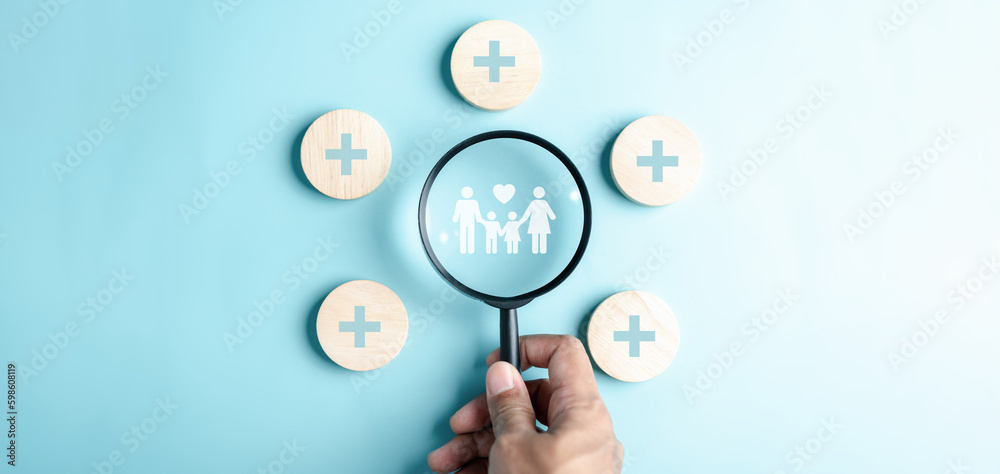 Health and Life insurance of protect family concept. Magnifier focus to family icon with healthcare medical icon on wooden cube block, health and access to welfare health concept