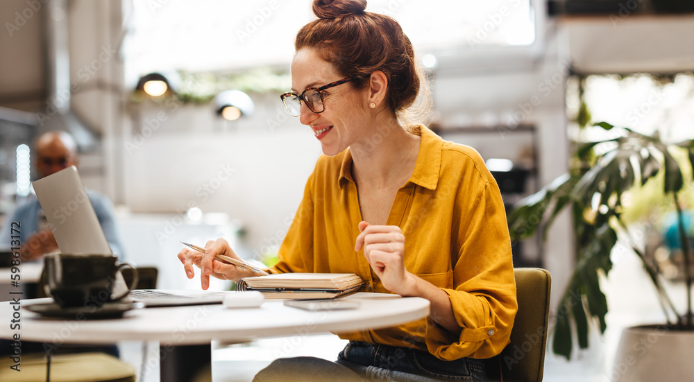 Female postgrad student student working on her thesis in a cafe Female postgrad student student working on her thesis in a cafe